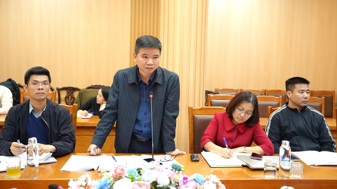 A person standing at a desk with a microphone  AI-generated content may be incorrect.