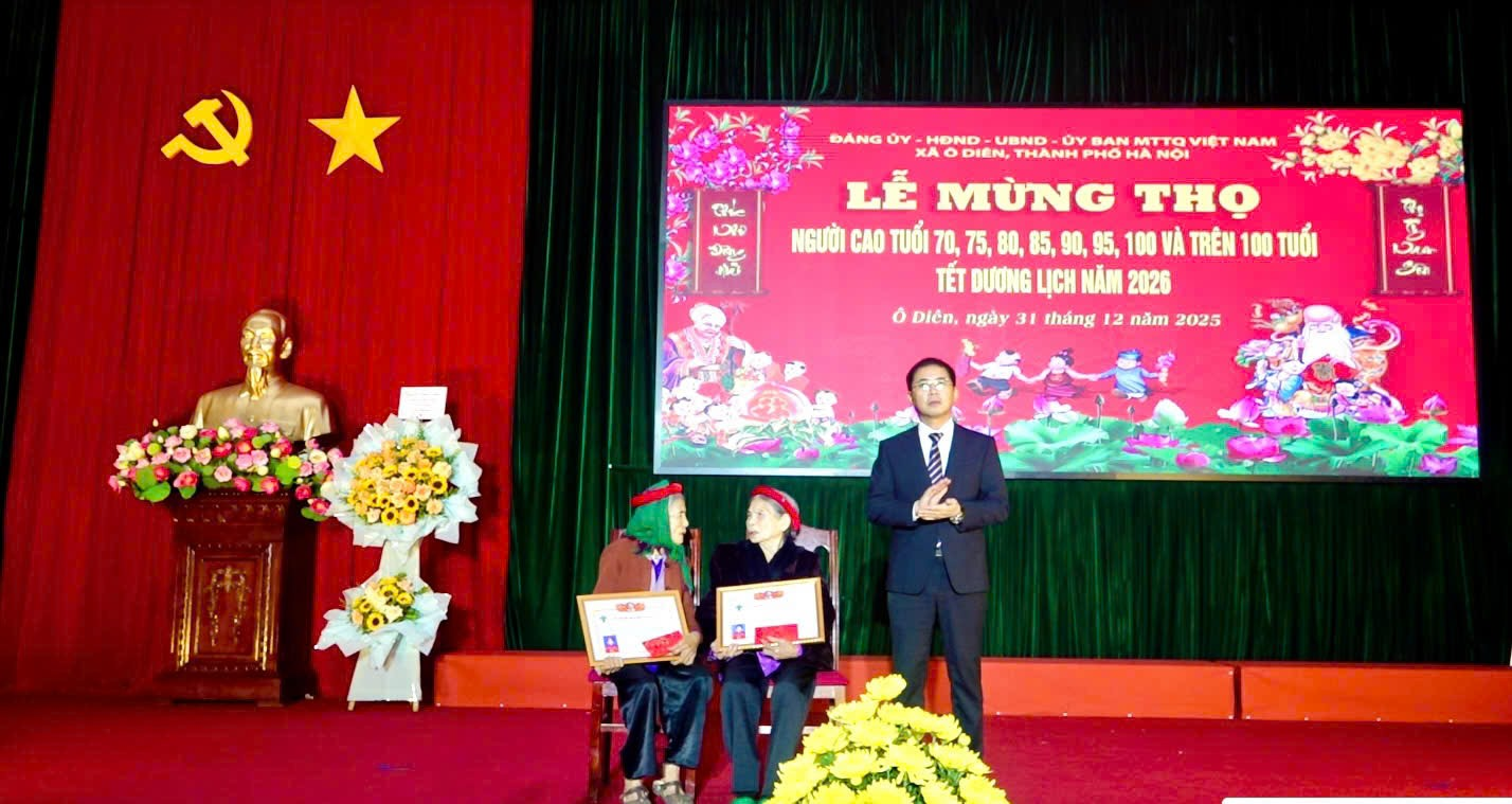 A person standing on a stage with a person standing on a stage  Description automatically generated