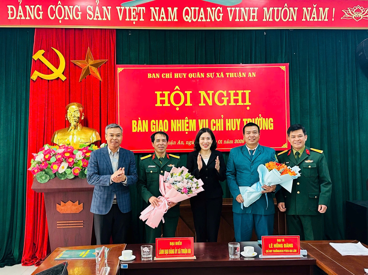 A group of people standing in front of a red and green curtain  AI-generated content may be incorrect.