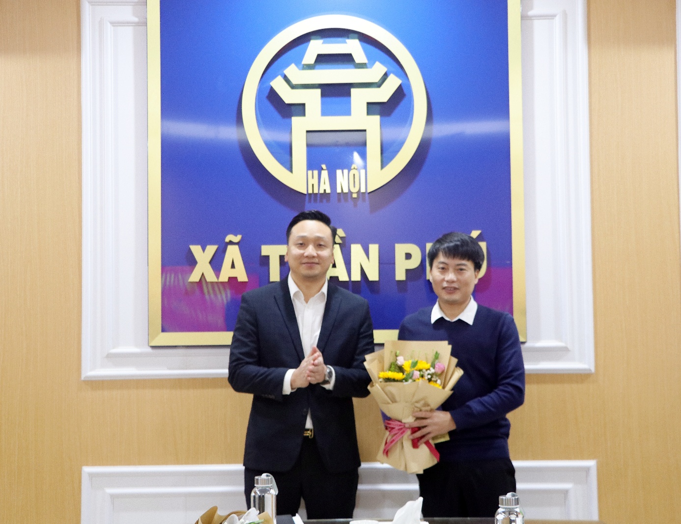 Two men standing in front of a sign  AI-generated content may be incorrect.