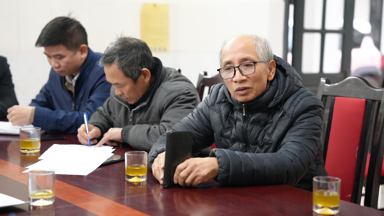 A group of men sitting at a table  AI-generated content may be incorrect.