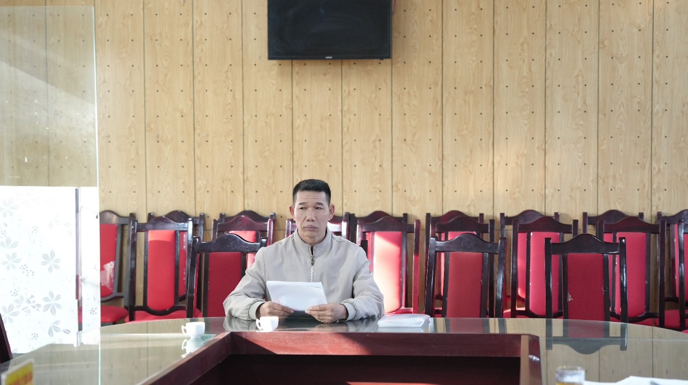 A person sitting at a table with a paper in his hand  AI-generated content may be incorrect.