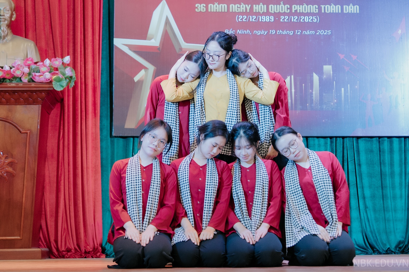 A group of women in red and white outfits on a stage  Description automatically generated