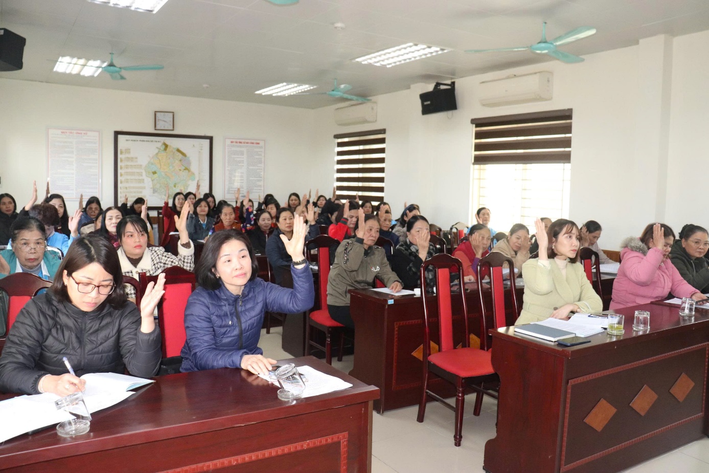 A group of people in a classroom raising their hands  AI-generated content may be incorrect.