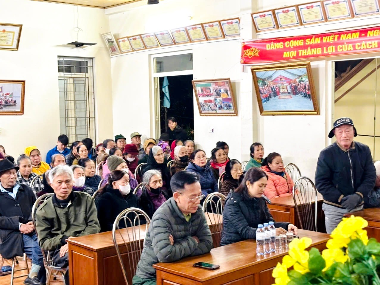 A group of people sitting at desks in a room  Description automatically generated