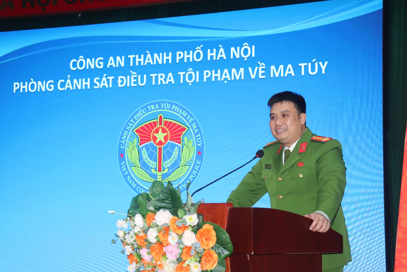 A person in a green uniform standing at a podium  AI-generated content may be incorrect.