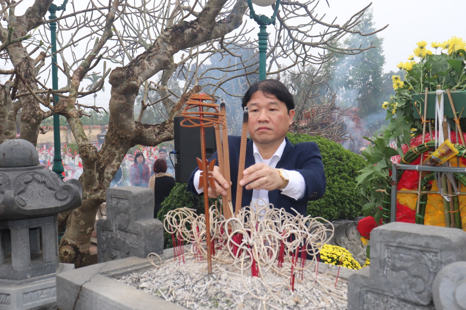 A person holding incense sticks  AI-generated content may be incorrect.