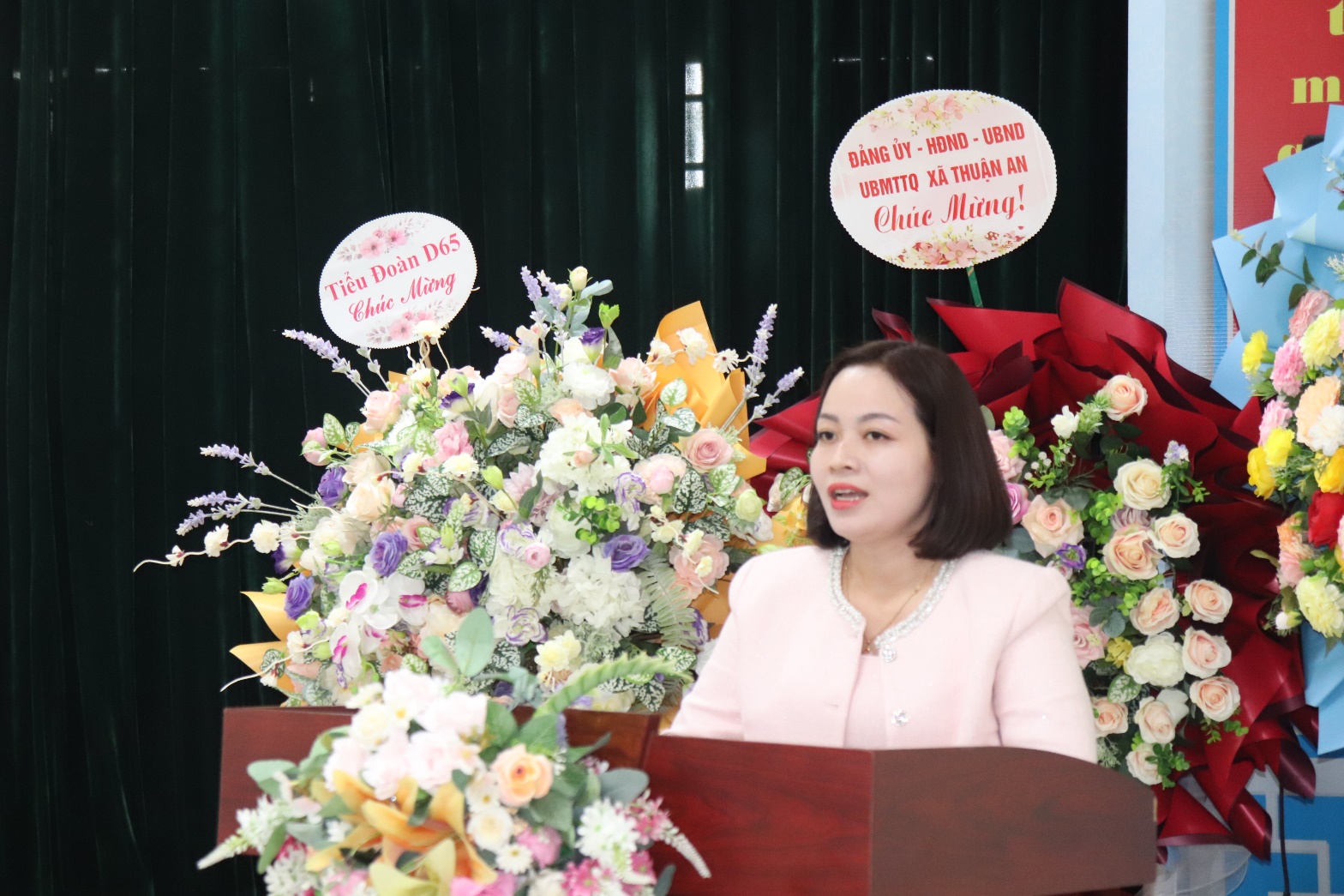 A person standing at a podium with flowers  AI-generated content may be incorrect.