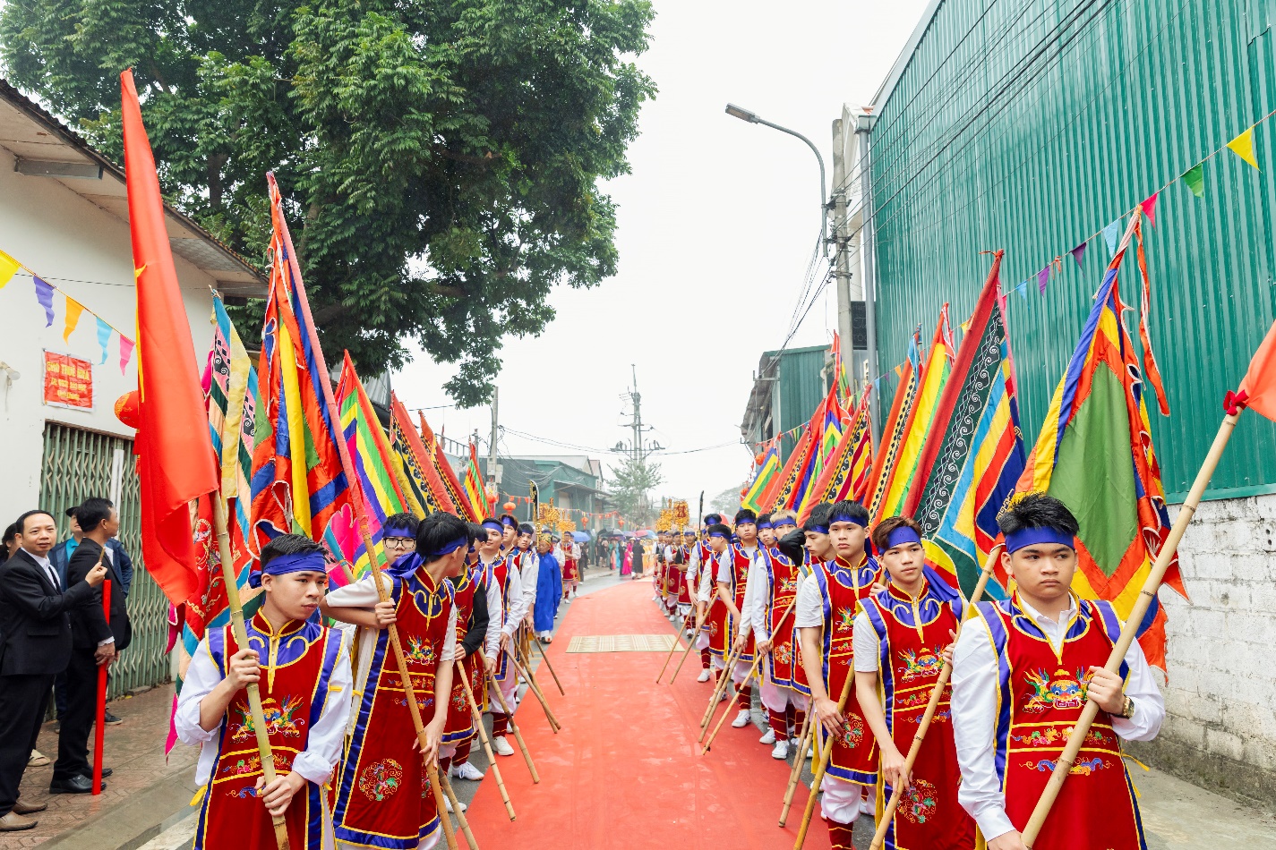 A group of people in clothing carrying flags  AI-generated content may be incorrect.
