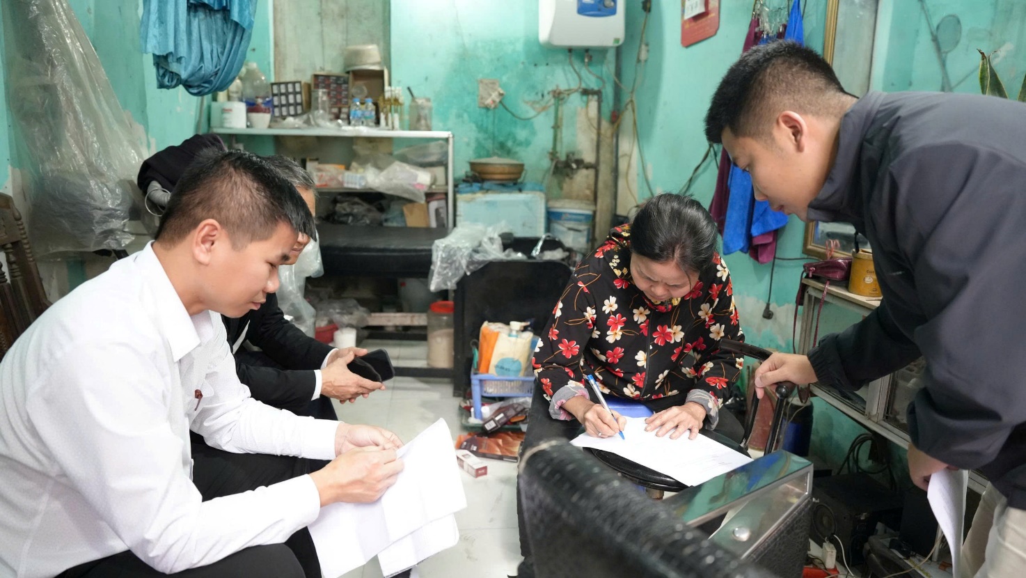 A group of people working on papers  AI-generated content may be incorrect.