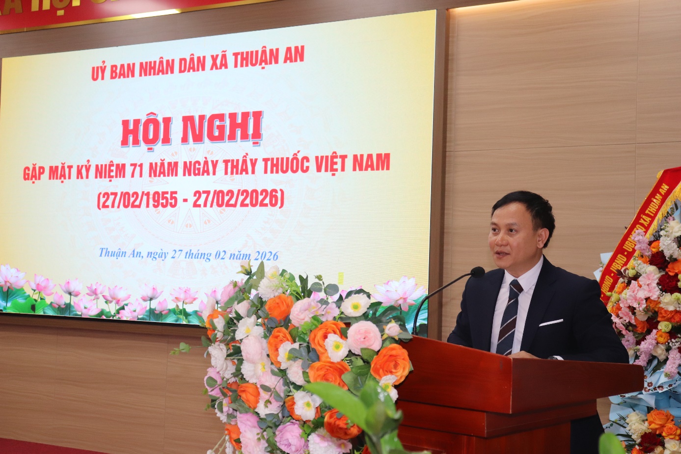 A person standing at a podium with a microphone  AI-generated content may be incorrect.