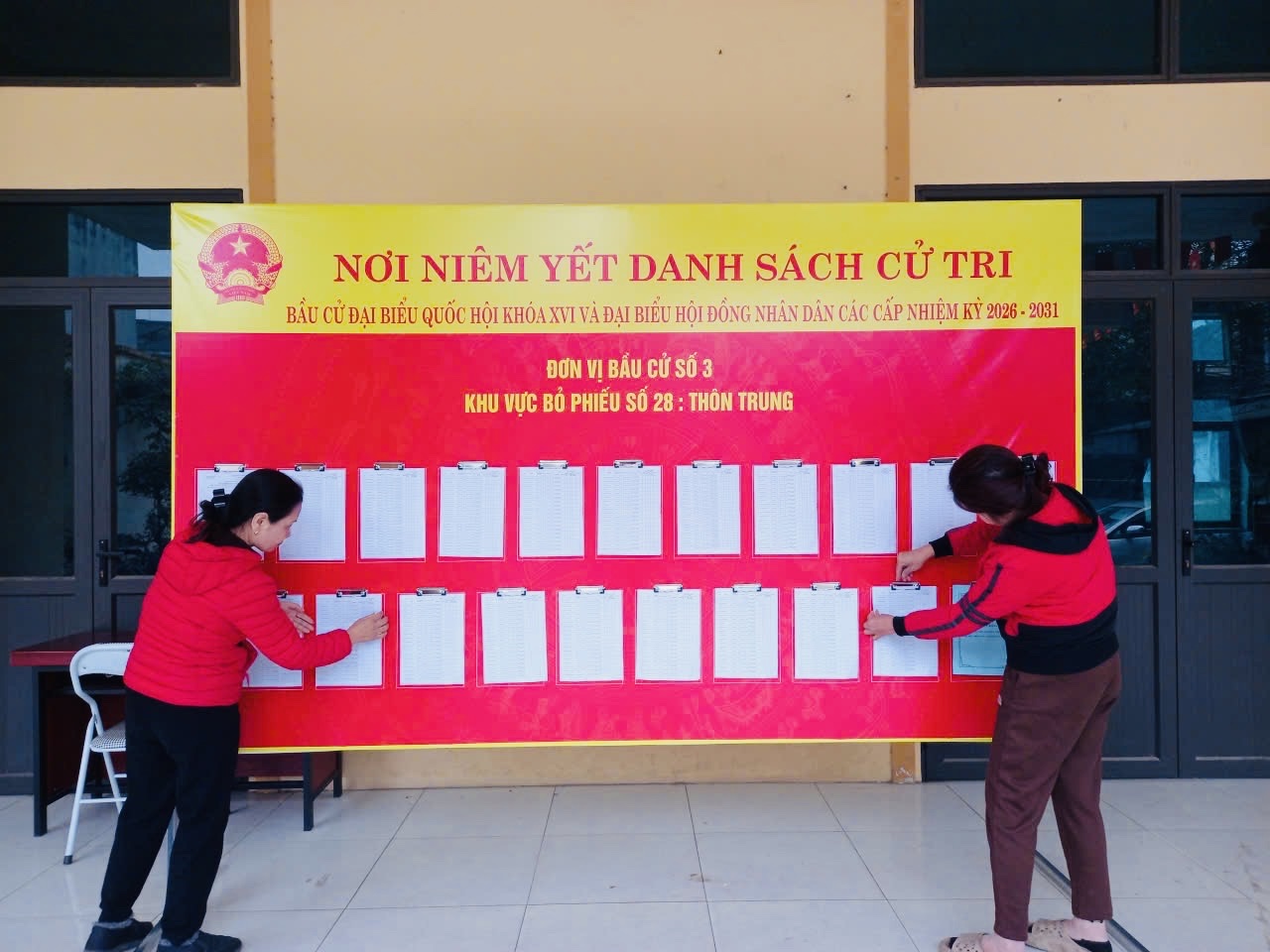 A group of women standing next to a large board with white paper  AI-generated content may be incorrect.