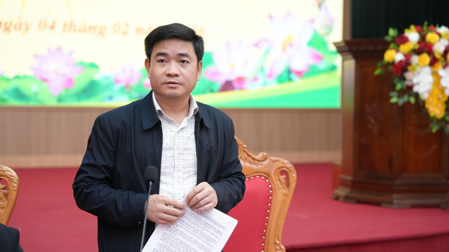 A person standing in front of a microphone  AI-generated content may be incorrect.