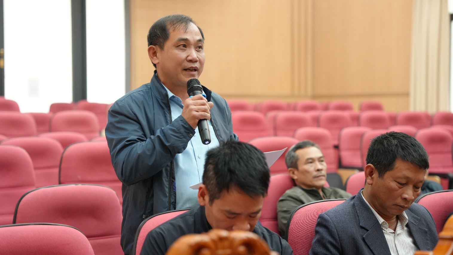 A person speaking into a microphone  AI-generated content may be incorrect.