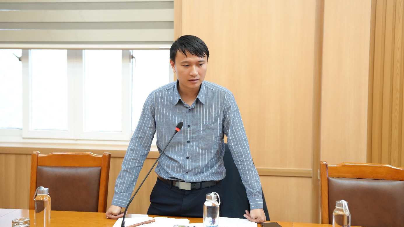 A person standing at a table with a microphone  AI-generated content may be incorrect.