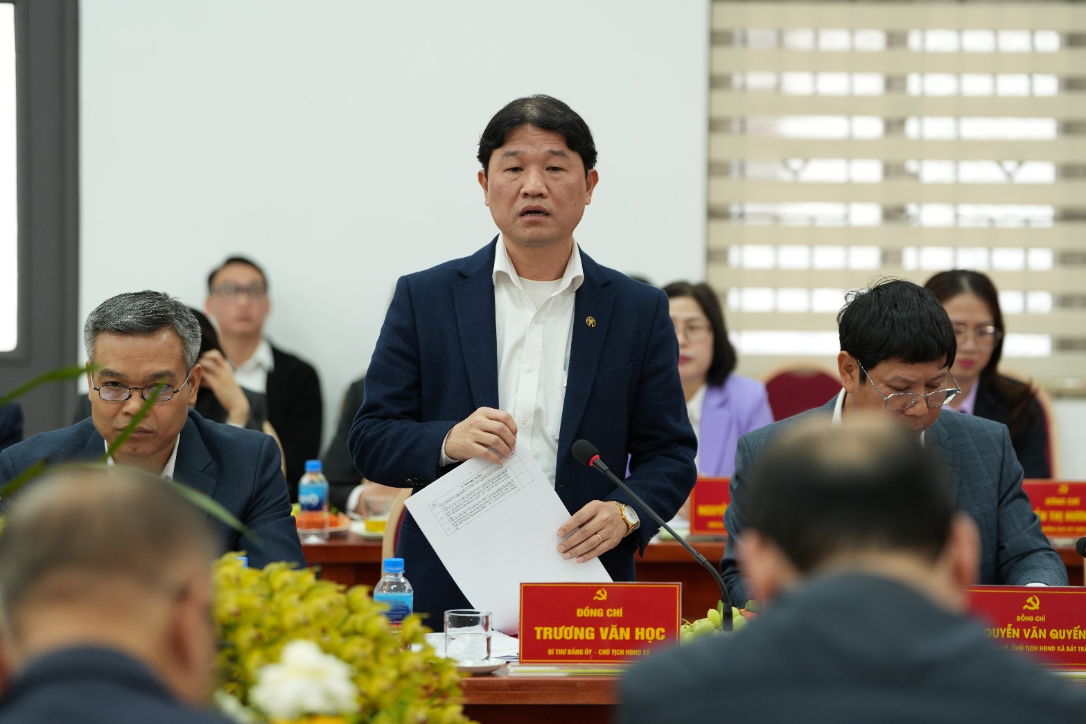 A person standing in front of a microphone  AI-generated content may be incorrect.