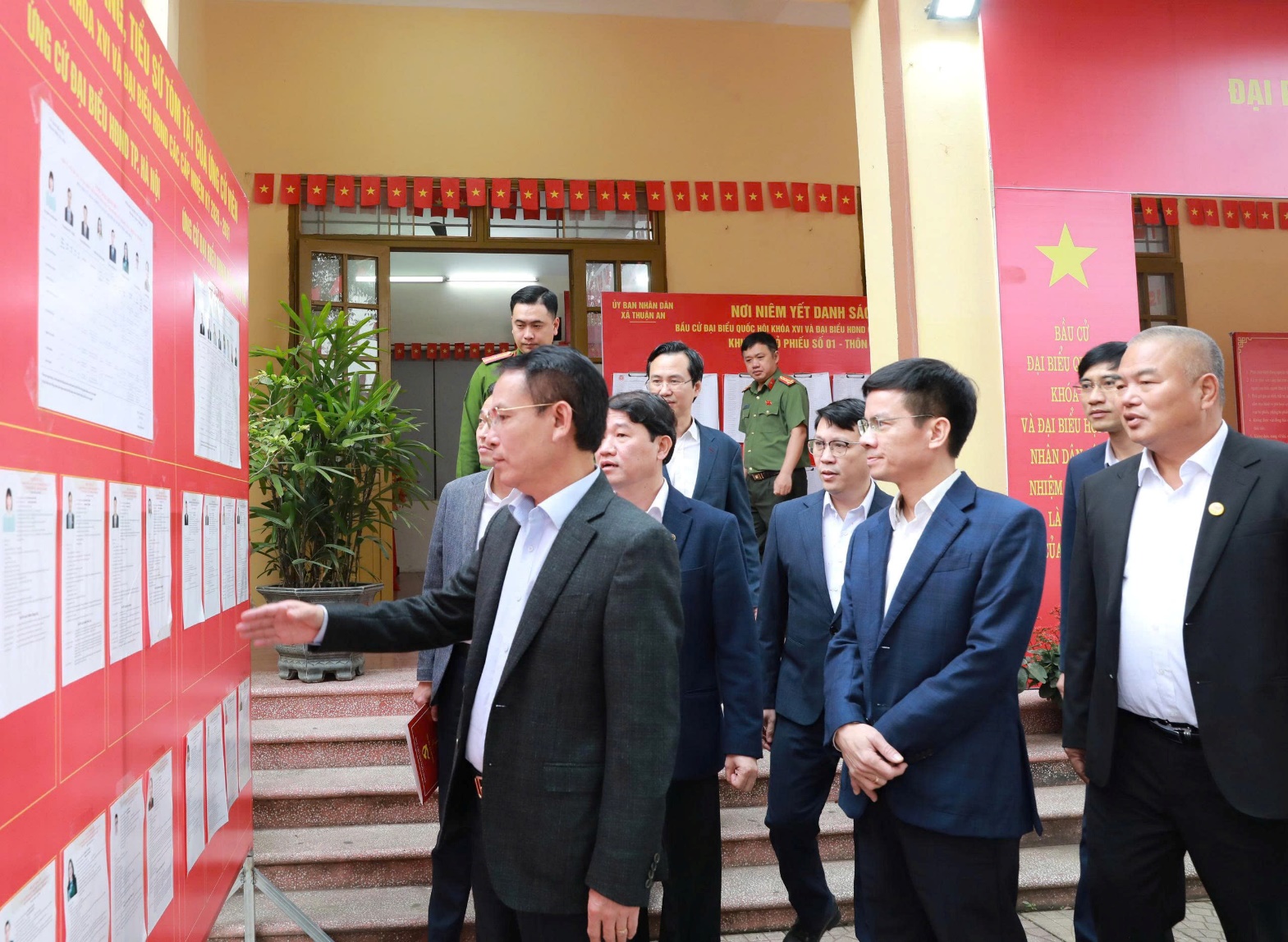 A group of men standing next to a poster  AI-generated content may be incorrect.