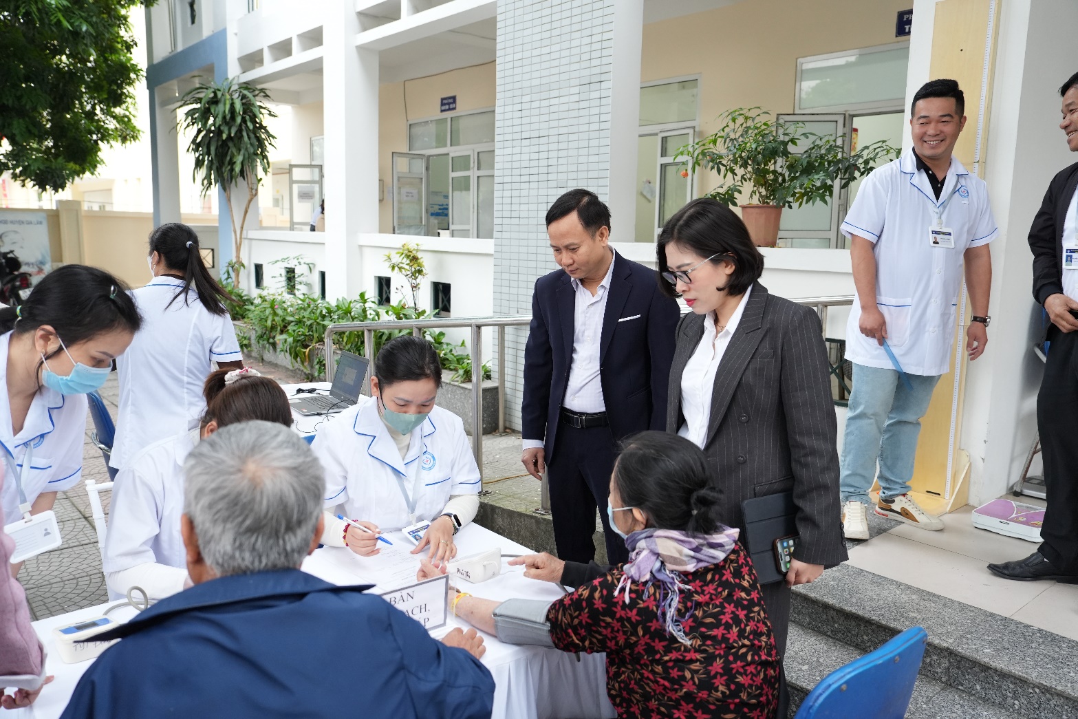 A group of people standing around a table  AI-generated content may be incorrect.