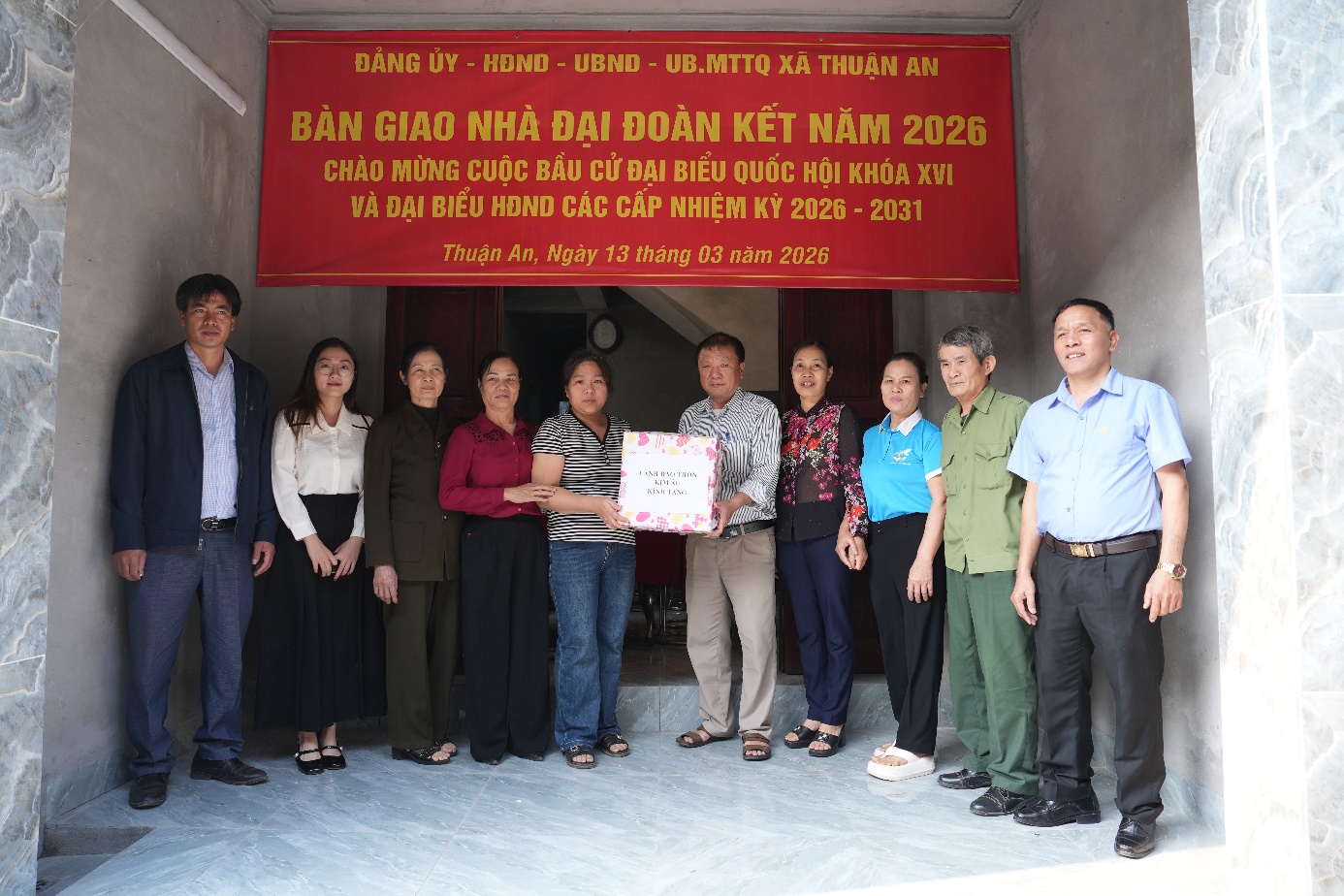 A group of people standing in front of a red banner  AI-generated content may be incorrect.