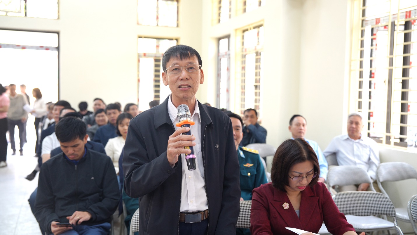 A person holding a microphone in front of a group of people  AI-generated content may be incorrect.