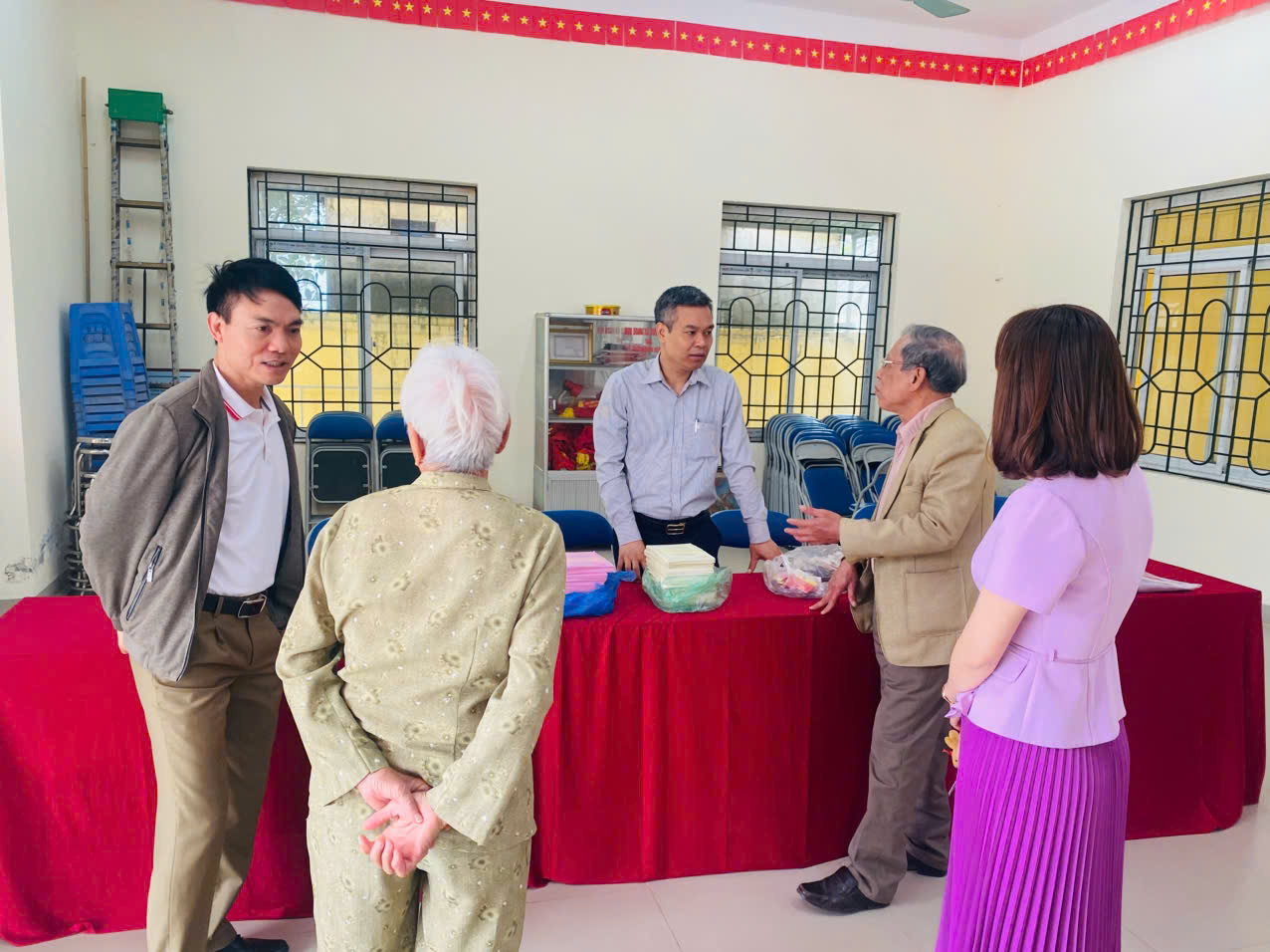 A group of people standing around a table  AI-generated content may be incorrect.