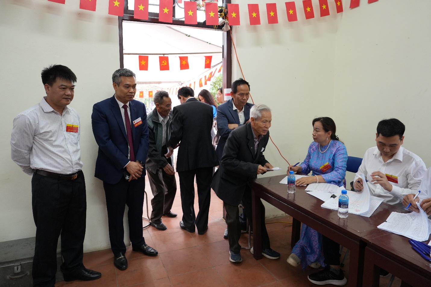 A group of people standing around a table  AI-generated content may be incorrect.