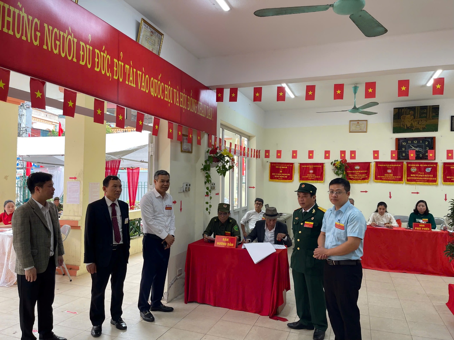 A group of people standing in a room with red flags  AI-generated content may be incorrect.