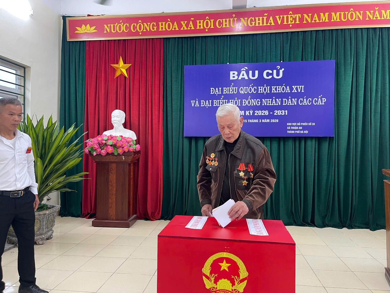 A person standing at a red box with papers  AI-generated content may be incorrect.