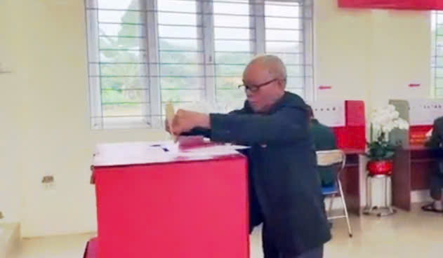 A person putting a piece of paper in a ballot box  AI-generated content may be incorrect.