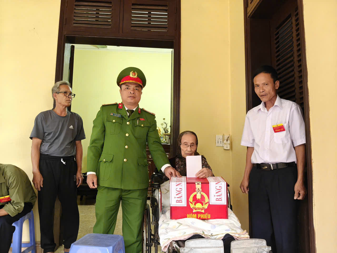 A person in a green uniform standing next to a person in a wheelchair  AI-generated content may be incorrect.