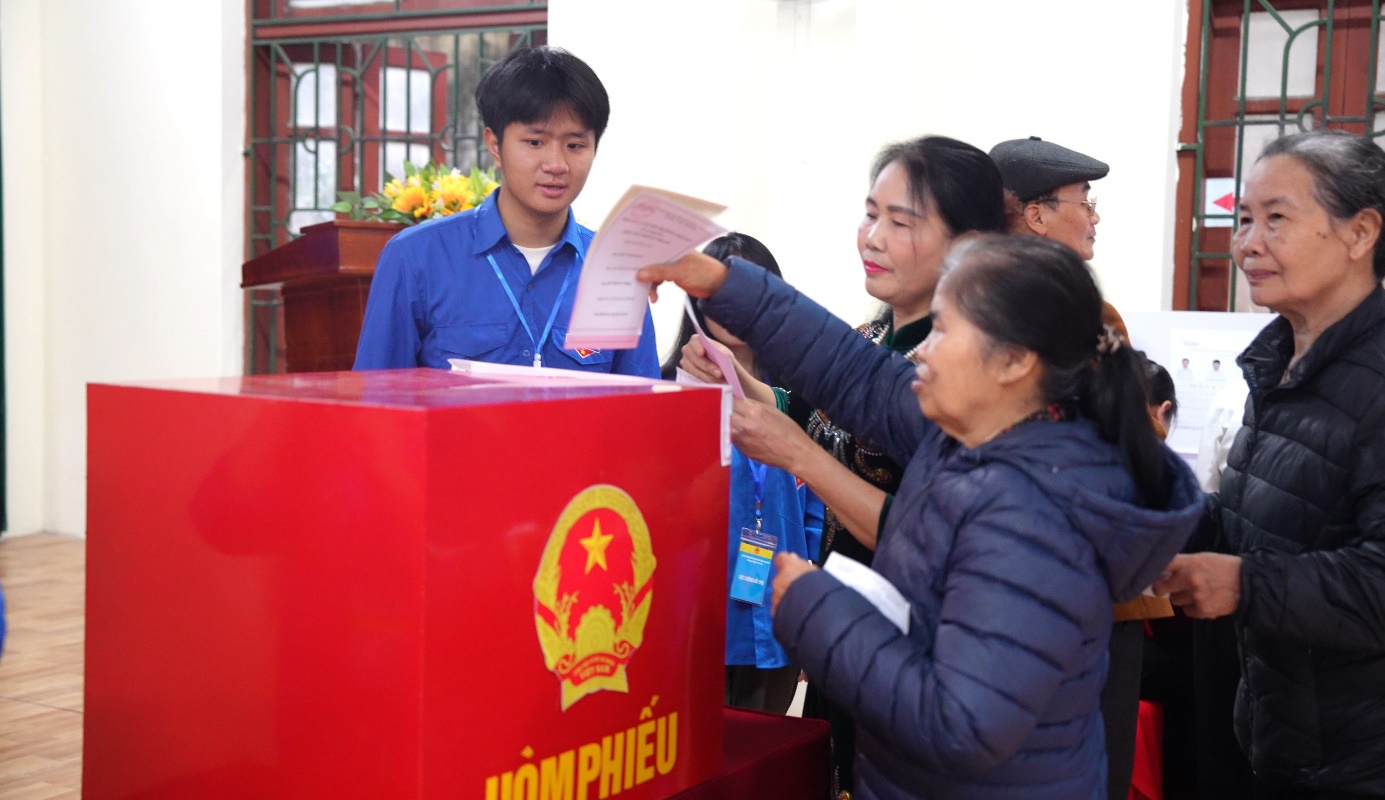 A group of people voting in a ballot box  AI-generated content may be incorrect.