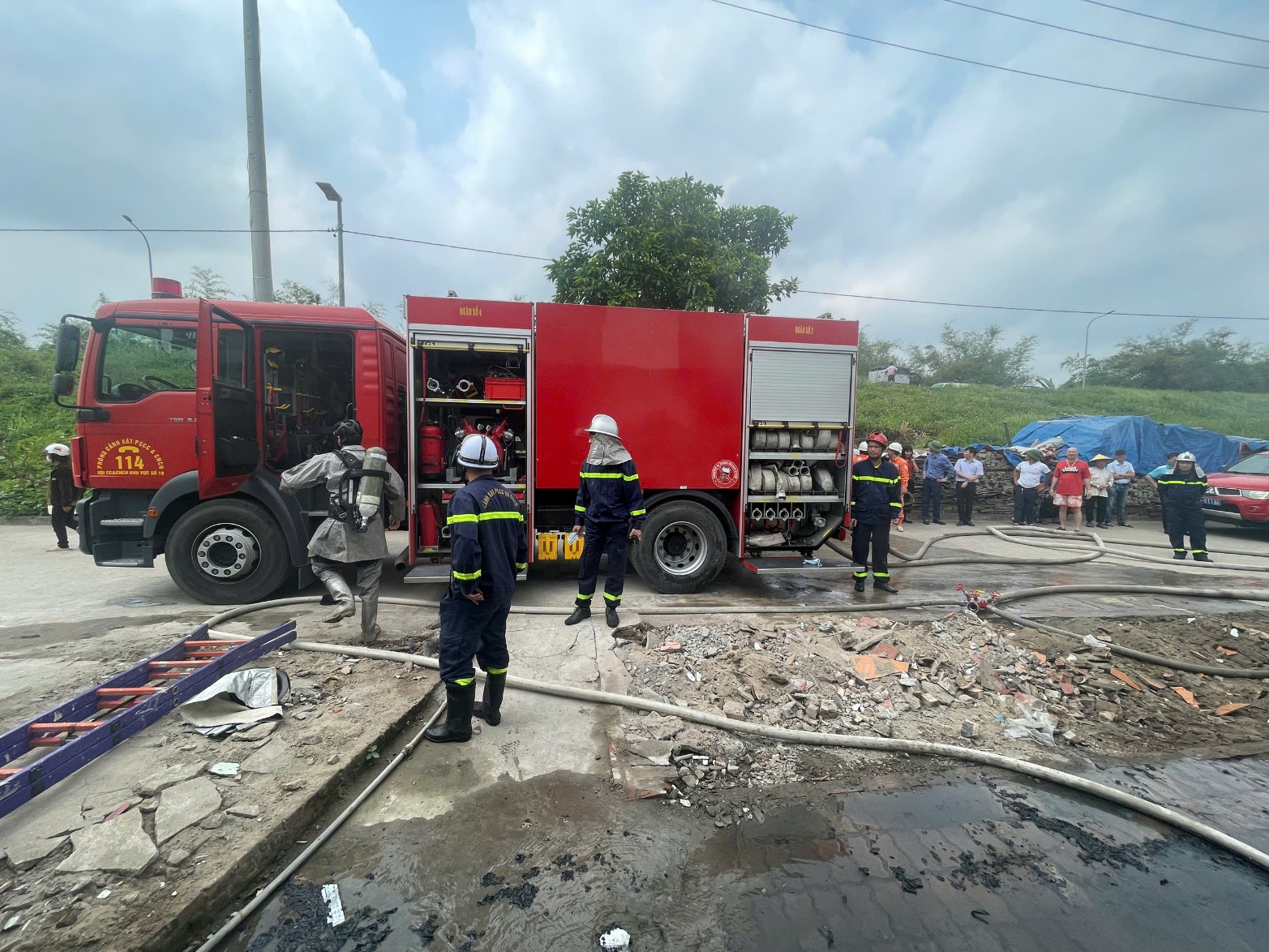 A group of firefighters standing next to a fire truck  AI-generated content may be incorrect.