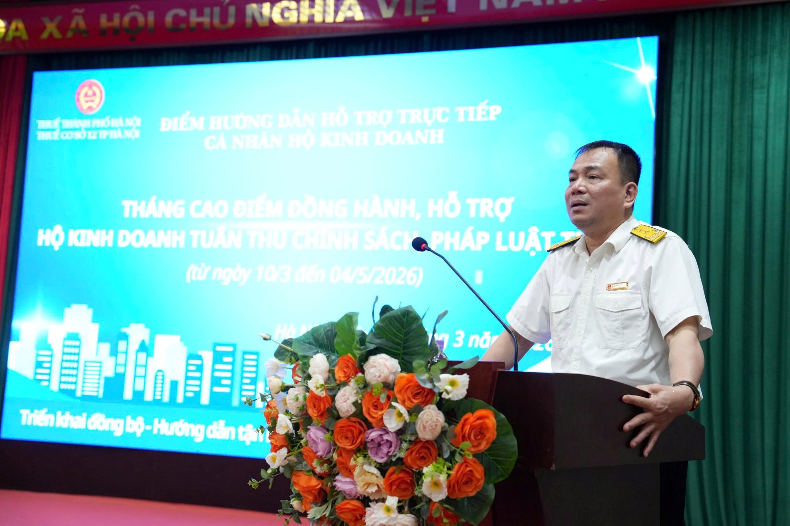 A person standing at a podium with a microphone  AI-generated content may be incorrect.