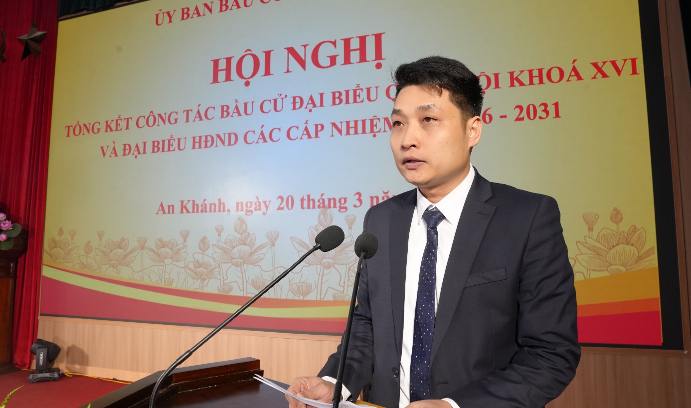 A person in a suit and tie standing in front of microphones  AI-generated content may be incorrect.