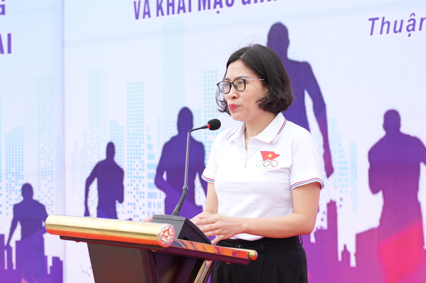 A person standing at a podium speaking into a microphone  AI-generated content may be incorrect.