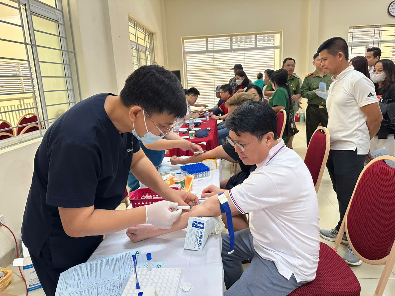 A person getting blood sample from a person  AI-generated content may be incorrect.