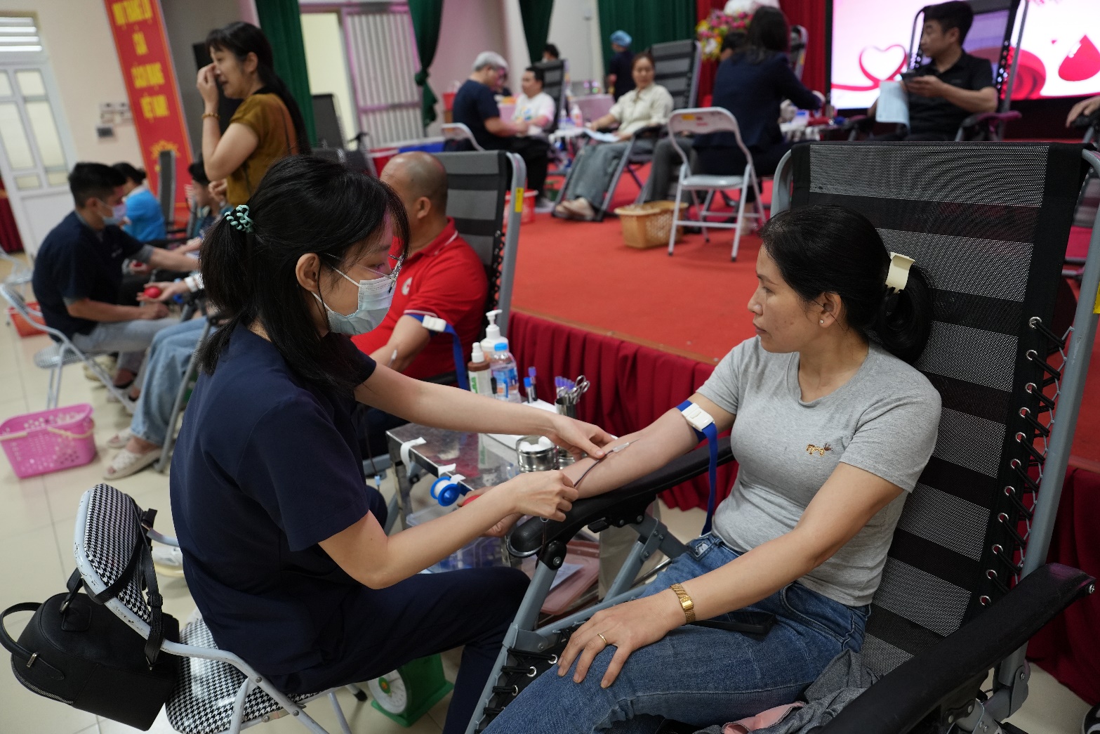 A nurse taking a blood sample of a person  AI-generated content may be incorrect.