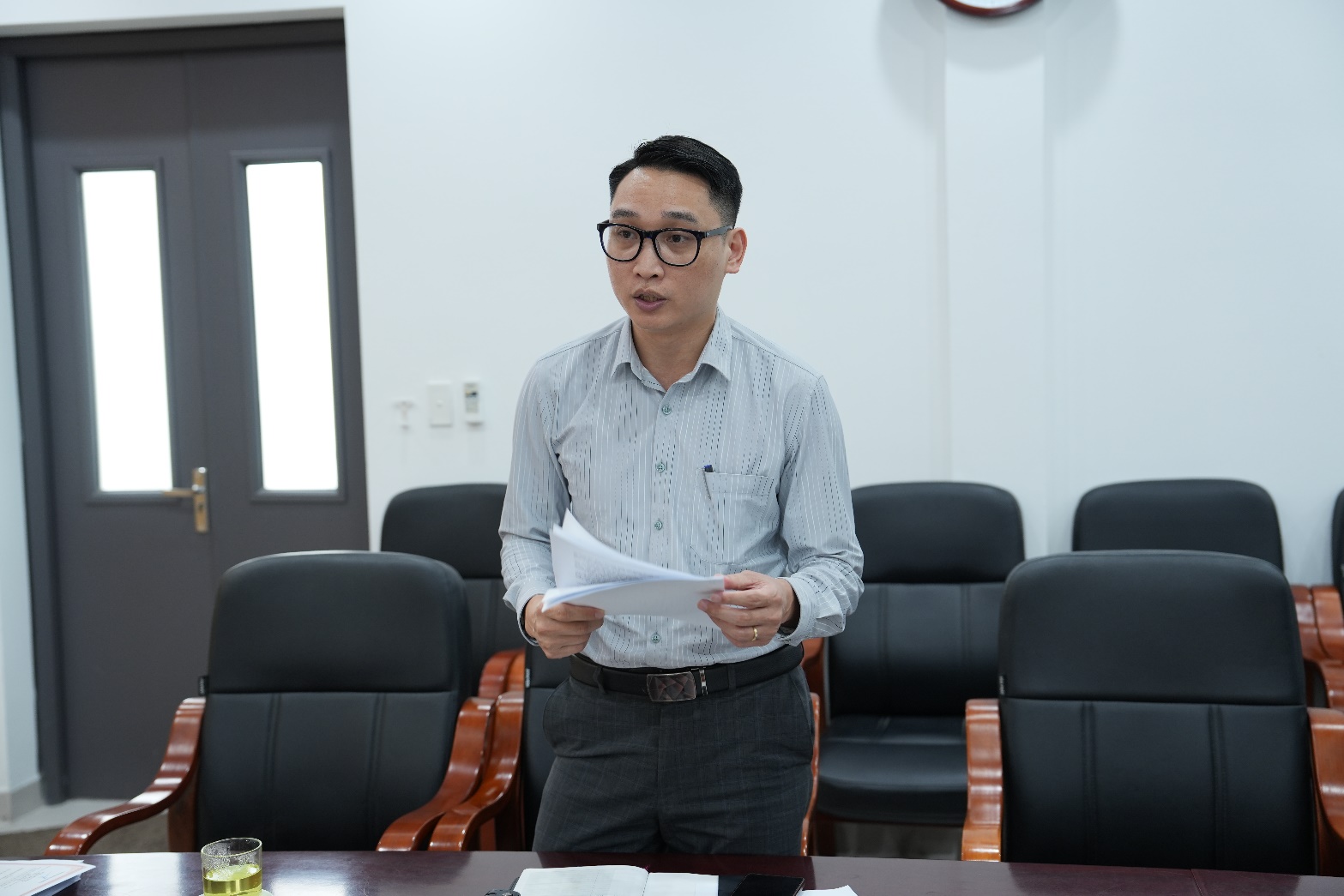 A person standing in front of a table with papers  AI-generated content may be incorrect.