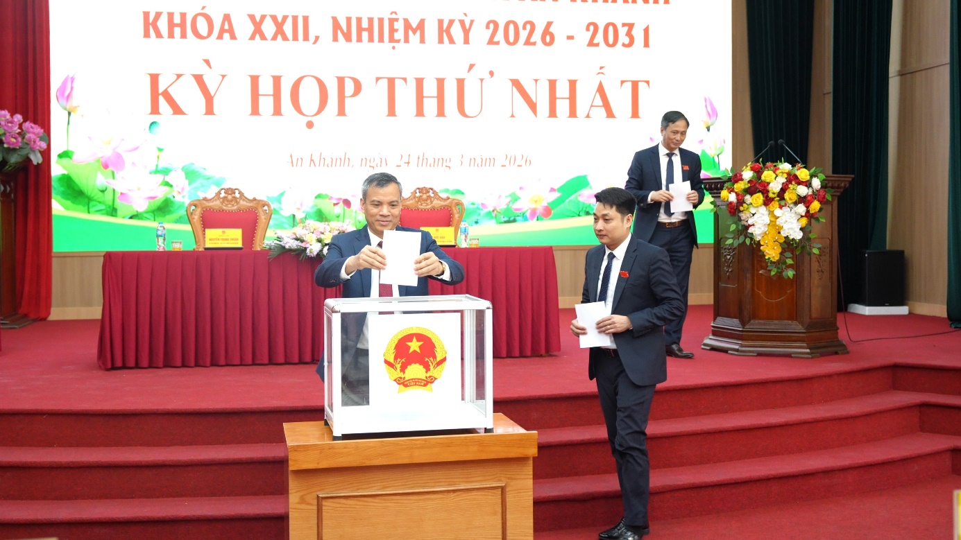 A person in a suit standing at a podium with a sign on it  AI-generated content may be incorrect.