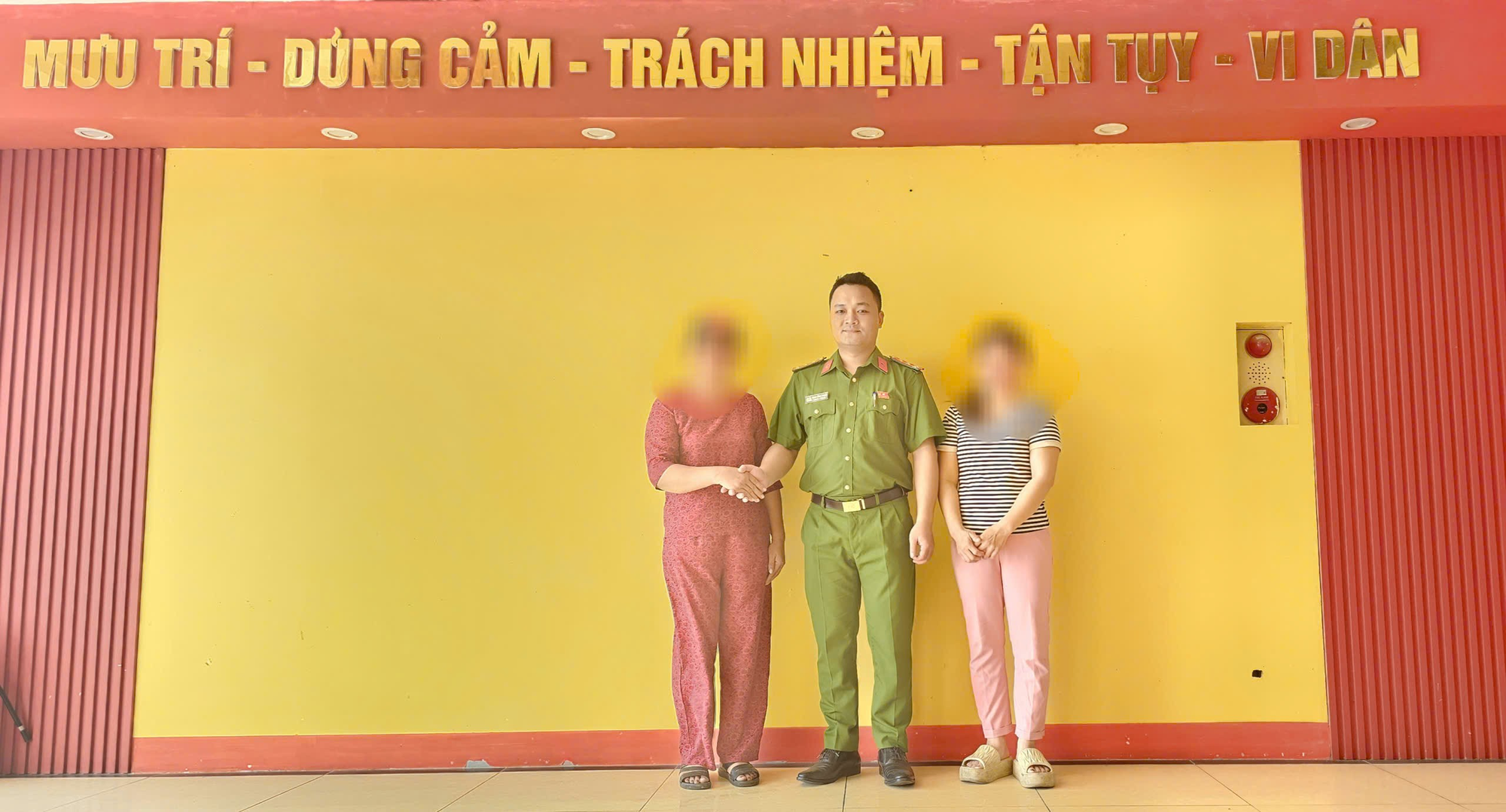 A group of people standing in front of a yellow wall  Description automatically generated