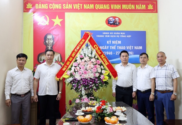 Đồng chí Chủ tịch UBND xã Xuân Mai Nguyễn Anh Đức tặng hoa chúc mừng Trung tâm Dịch vụ tổng hợp xã nhân kỷ niệm 80 năm Ngày truyền thống ngành thể dục, thể thao Việt Nam 27/3- Ảnh 1.