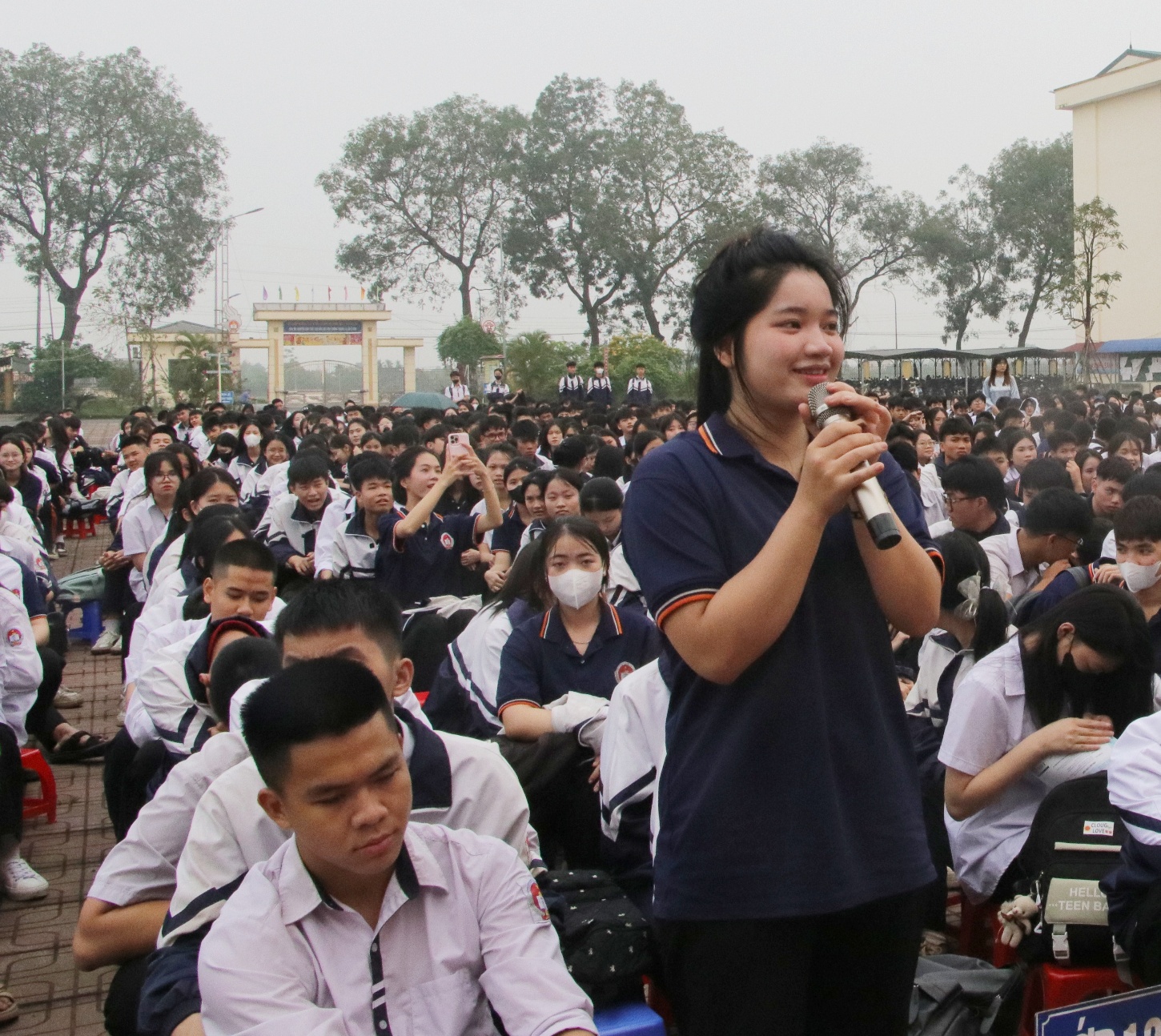 A person speaking into a microphone in front of a large crowd of people  AI-generated content may be incorrect.