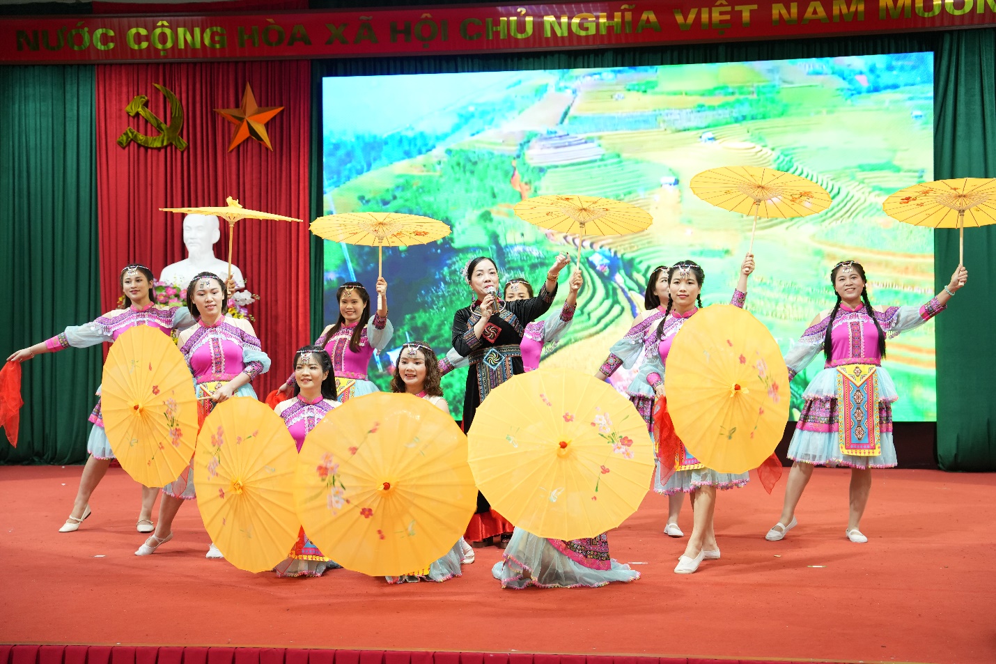 A group of people on a stage holding umbrellas  AI-generated content may be incorrect.