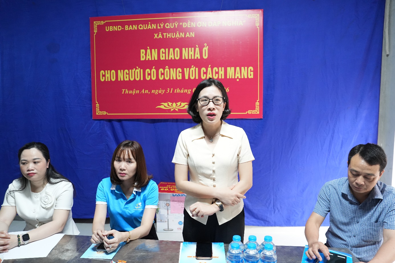 A group of people standing in front of a blue banner  AI-generated content may be incorrect.