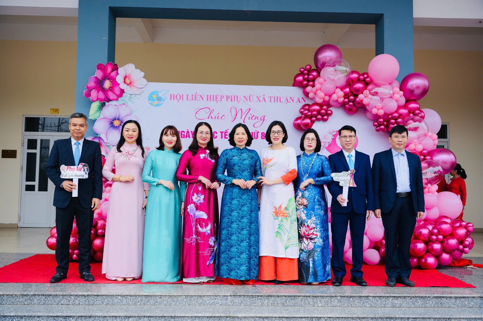 A group of people standing in front of a banner  AI-generated content may be incorrect.