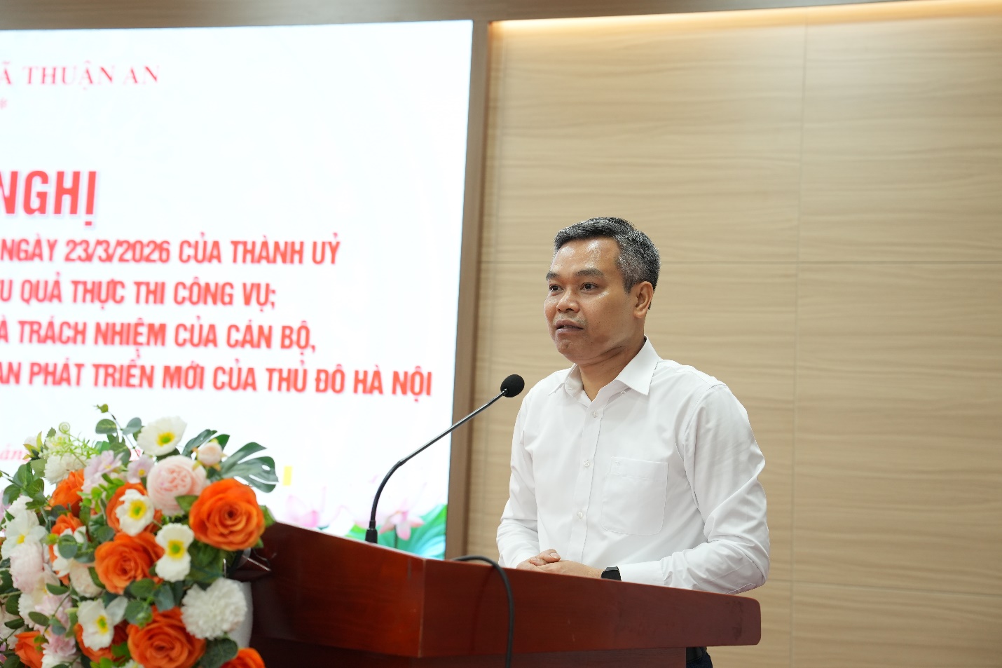 A person standing at a podium with a microphone  AI-generated content may be incorrect.