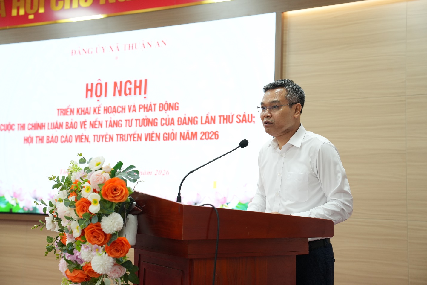 A person standing at a podium with a microphone  AI-generated content may be incorrect.