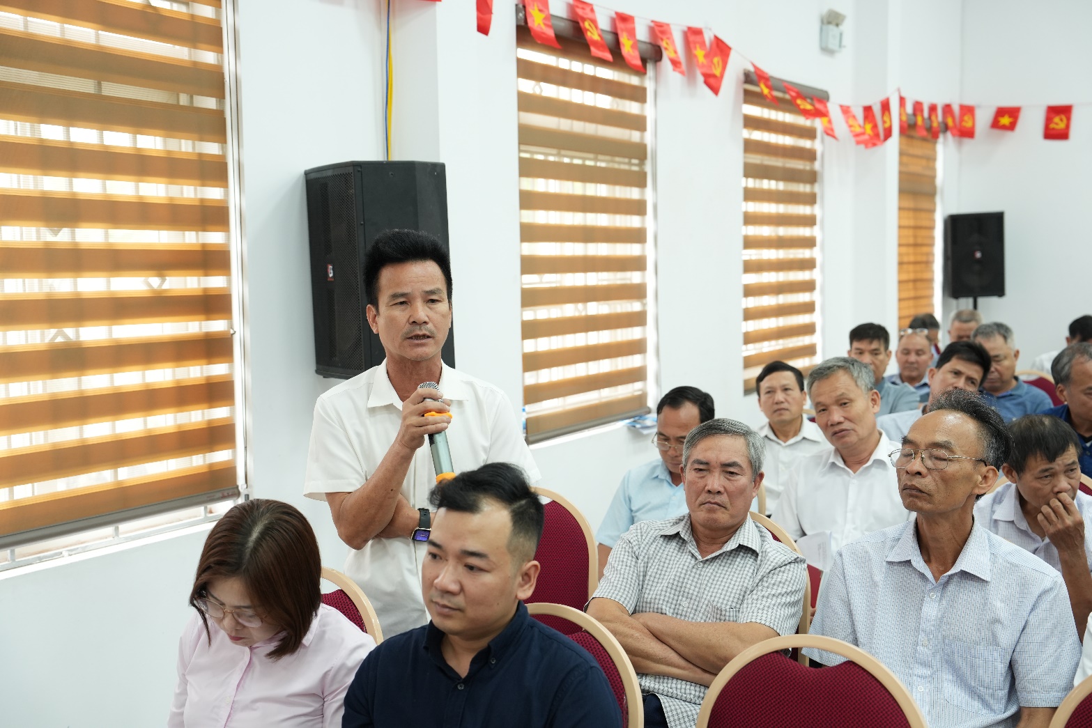 A person speaking to a group of people  AI-generated content may be incorrect.