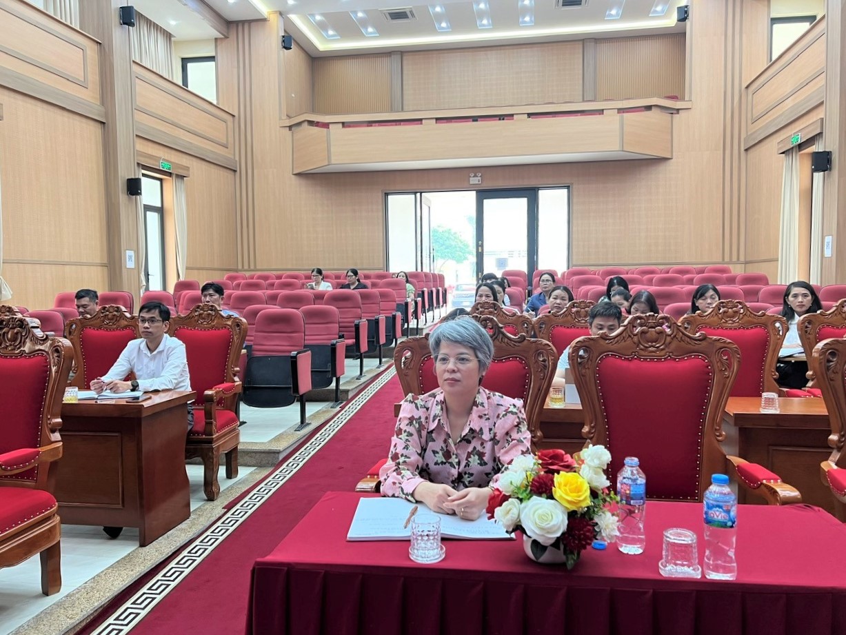 A group of people sitting at a table in a room with red chairs  AI-generated content may be incorrect.
