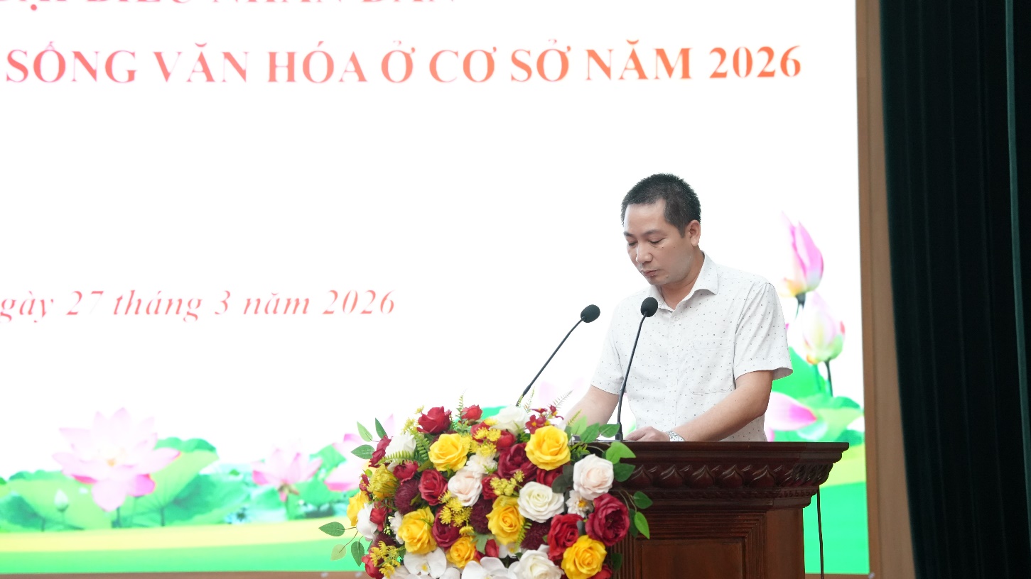 A person standing at a podium with a microphone and flowers  AI-generated content may be incorrect.